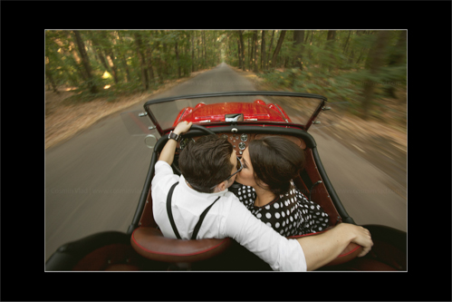50s engaged couple kissing while having a drive day through forest
