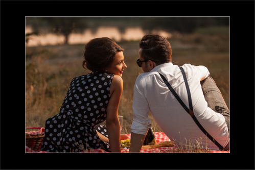 Engaged couple having a complete vintage picnic at sunset